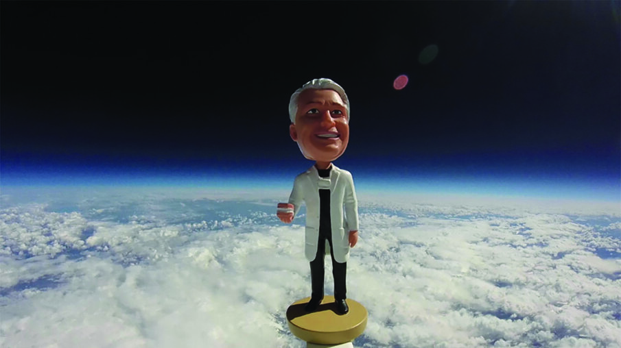 The Dr. Fischer bobblehead, floating tens-of-thousands of feet above Earth's surface.