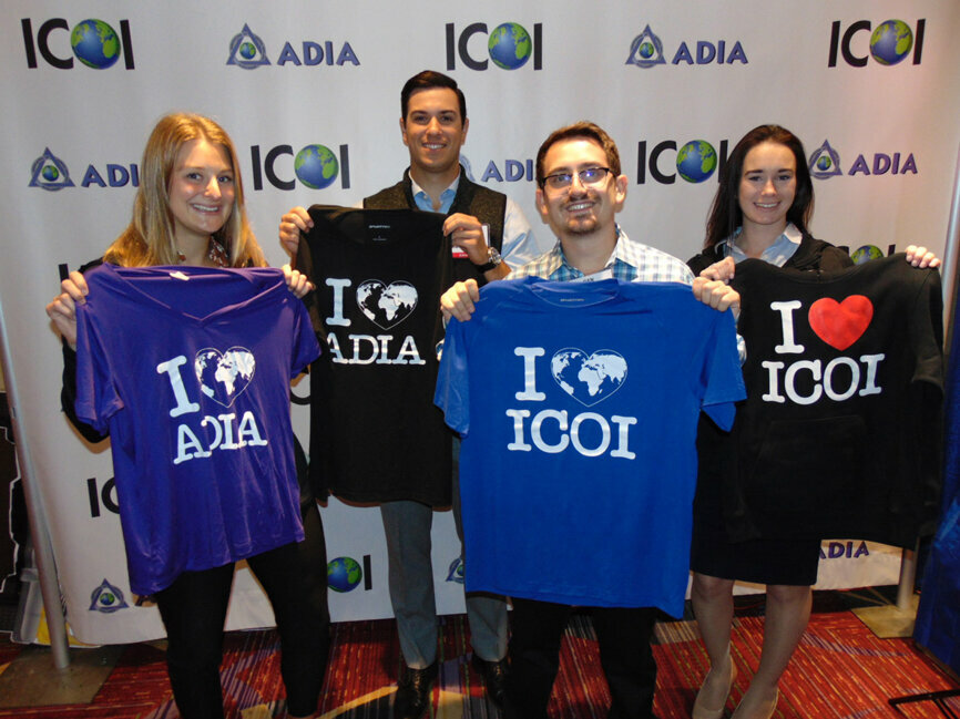 Lots of ICOI merch — including these T-shirts and sweatshirts — are available in the exhibit hall. From left: Rachel Belsky, Josh Cote, Dan Scotti and Larissa Lohman. (Photo: Fred Michmershuizen/DTA)